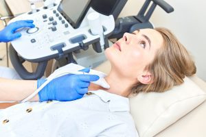 woman getting ultrasound to check thyroid gland