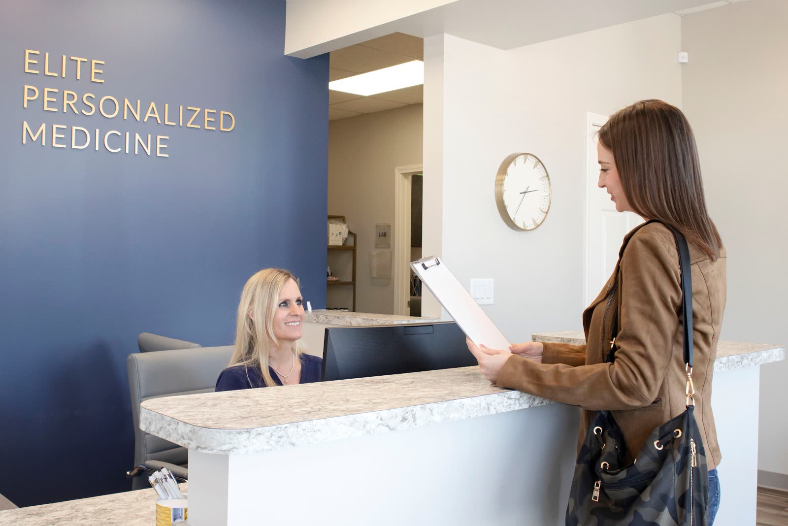 A patient checking in at the front desk of Elite Personalized Medicine in Dacula, GA